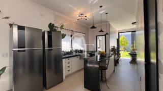 Casa Farm House térrea à venda no Condomínio UNA em Itu. Jardim com árvores frutíferas, 3 suítes e arquitetura com luz natural